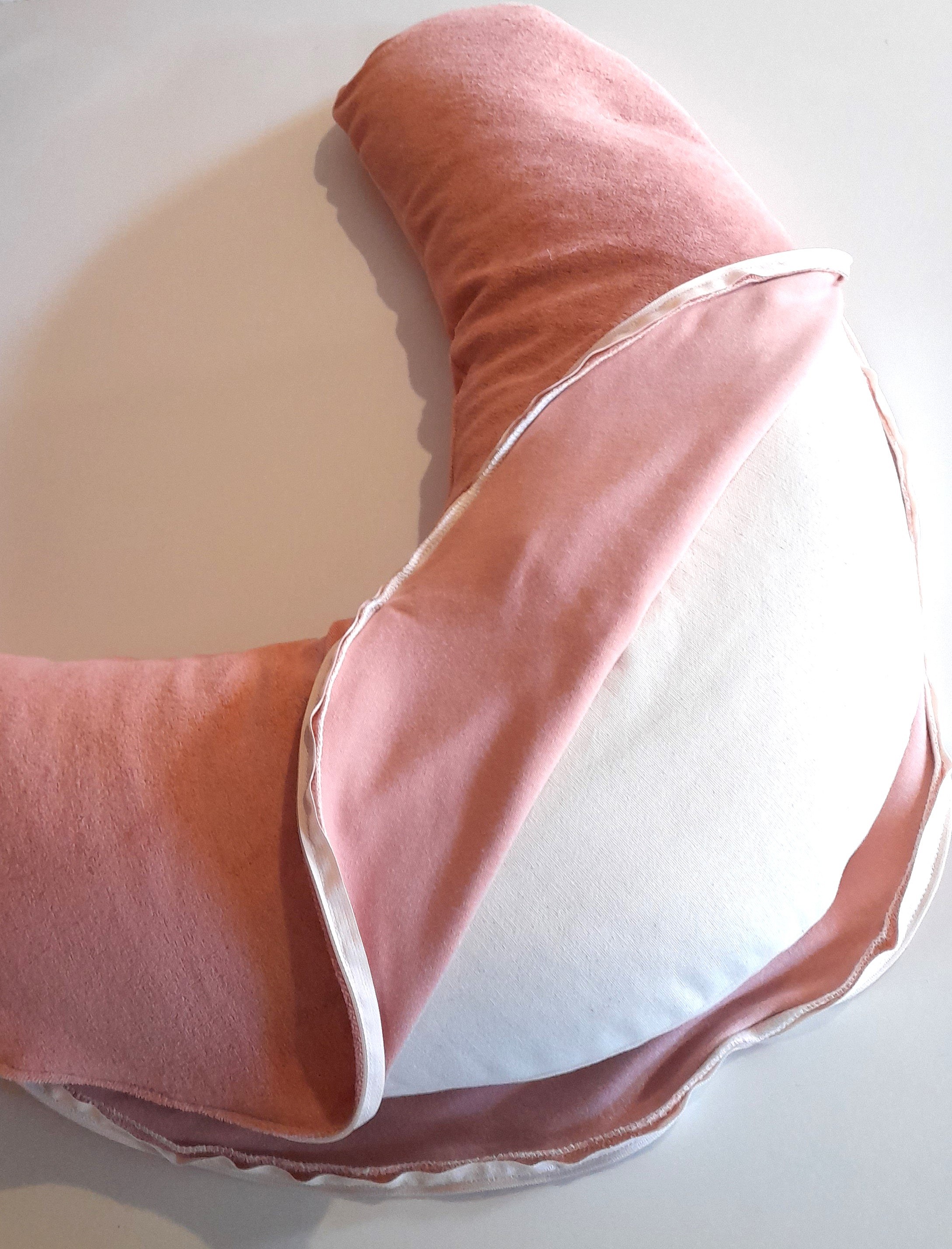 Coussin d'allaitement en forme de lune rose et blanc.